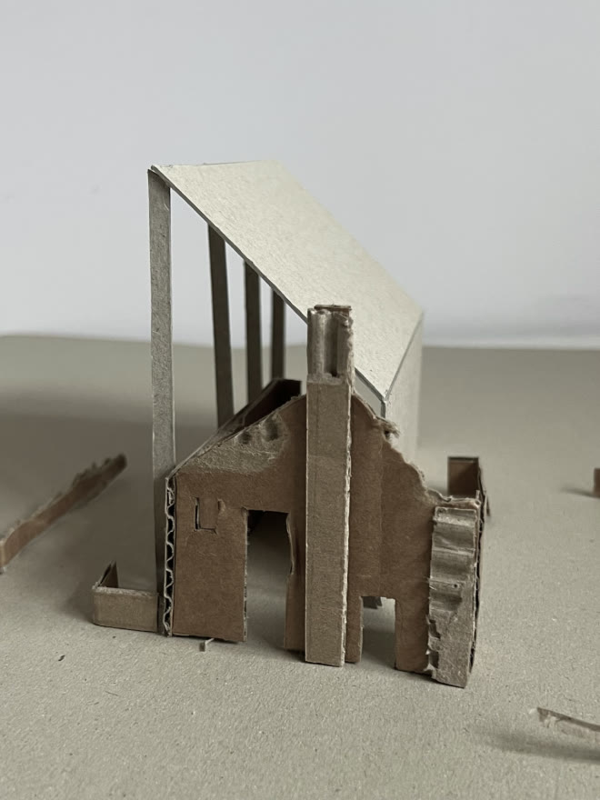 Cardboard study model — the volume raised clear on the wall head.